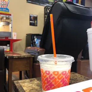  a drink in a plastic cup with a straw