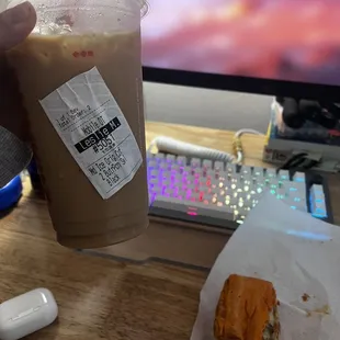  a person holding a cup of coffee and a sandwich