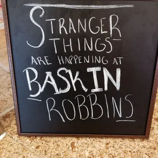  a blackboard with a sign saying strange things are happening at baskin robin robins