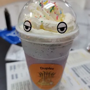 a cup with whipped cream and sprinkles