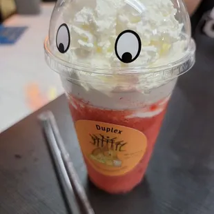 a cup of coffee with whipped cream and strawberries