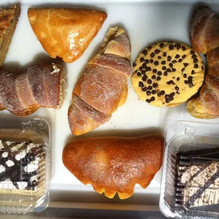 Tres leche cake, chocolate cake, bread pudding slice, apple turnover, pineapple thing, cream stuffed goodies, cookies.