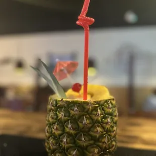 a pineapple with a straw in it