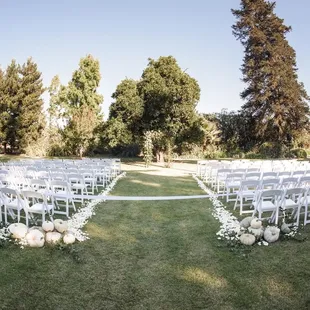 rows of white chairs set up for a wedding ceremony