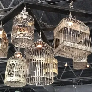 a group of bird cages hanging from the ceiling