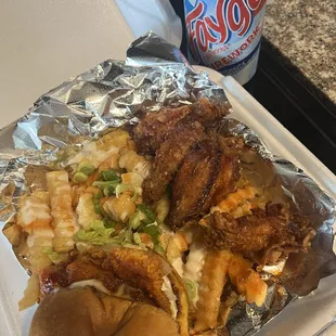 Fried salmon sandwich, wings, loaded fries and a faygo