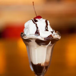 a chocolate sundae with whipped cream and a cherry on top