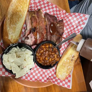 Ribs, potato salad, baked beans, and garlic bread