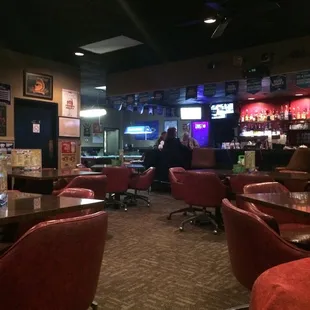 a bar with red chairs