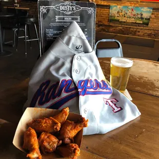 a tray of fried wings and a glass of beer