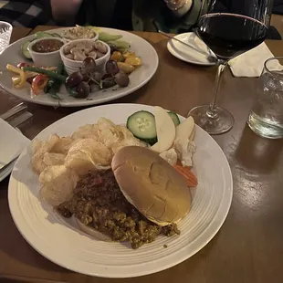 Sloppy Joe burger and vegan appetizer at the background with hummus