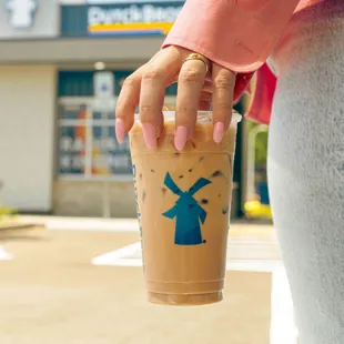 a hand holding a cup of iced coffee