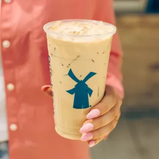 a woman holding a cup of iced coffee