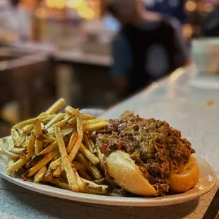 a plate of french fries and a pulled pork sandwich