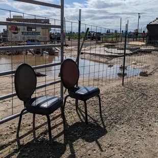 The eating area overlooks a dirty pond and discarded chairs