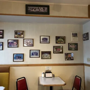 a table and chairs with pictures on the wall