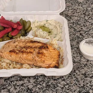 Salmon entree with a side of tangy yogurt sauce