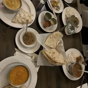 From top left to bottom right, palak paneer, goat curry, vegetable korma, chicken makhani, and Vegetable Samosa with mango in the middle!