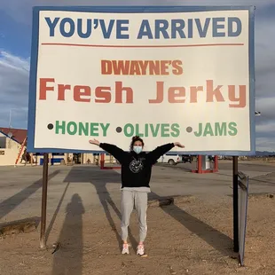 a woman standing in front of a sign