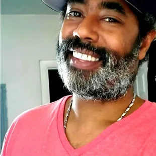 ows a man with a beard wearing a baseball cap