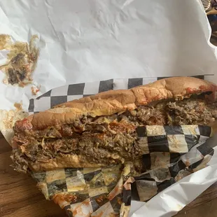 Just got a Philly cheesesteak hoagie that's oozing flavor and cheese.