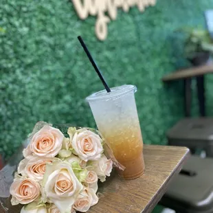 a cup of iced coffee and a bouquet of roses