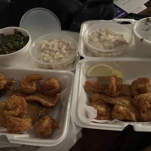 Two pieces of fish, five shrimps, lobster , turkey greens, and a macaroni salad