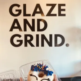 a hand holding a glazed and grind donut