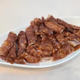 a plate of meat on a white table