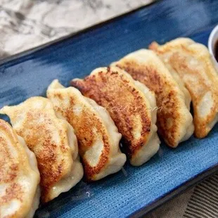 a plate of dumplings with dipping sauce