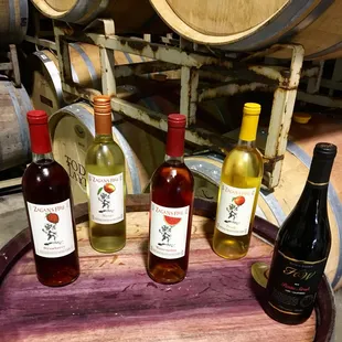 three bottles of wine on a barrel