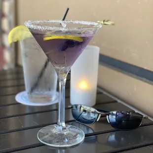 a purple cocktail in a martini glass