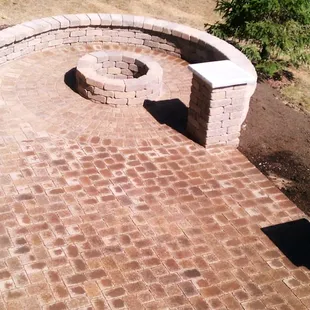 a brick patio with a fire pit