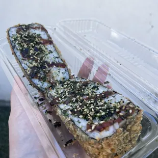 a hand holding a container of food
