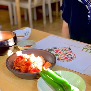 a woman sitting at a table with a bowl of food