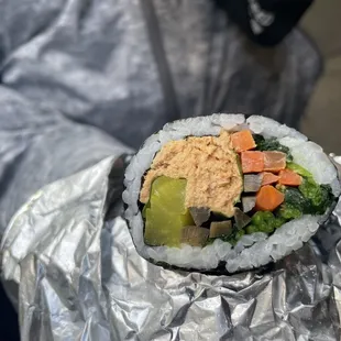 a person holding a piece of sushi