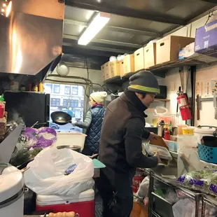 Inside the workings of E-San Thai food cart near Alder. it's small, but they still crank out great Thai food for cheap. Yes, they use woks!