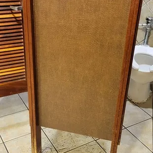 a bathroom stall with a toilet and a mirror