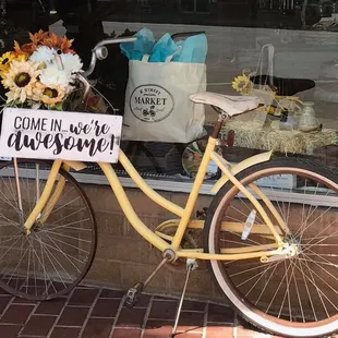 a yellow bicycle with flowers in the basket