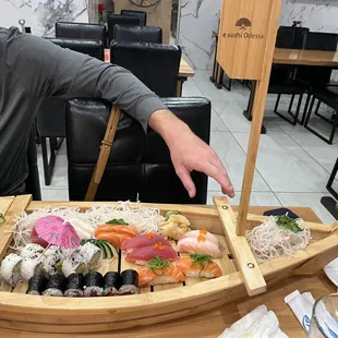 a man sitting at a table with sushi
