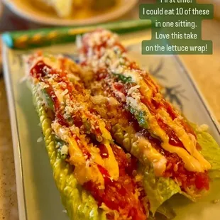 a plate of lettuce topped with cheese and sauce