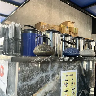 a variety of tea kettles on a counter