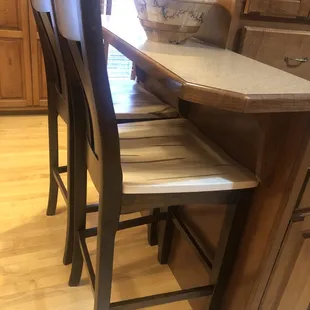 Bar stools in natural finish wormy maple seats and golden brown backs and legs.
