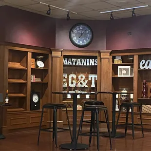 a bar with stools and a clock