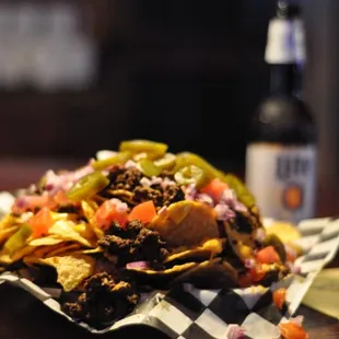 a plate of nachos and a bottle of beer