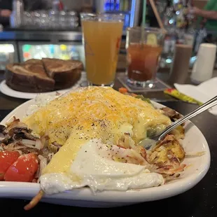 Veggie skillet with drinks in background.
