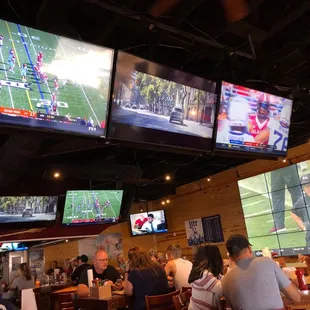 A load of TVs with college football playing on all the screens.