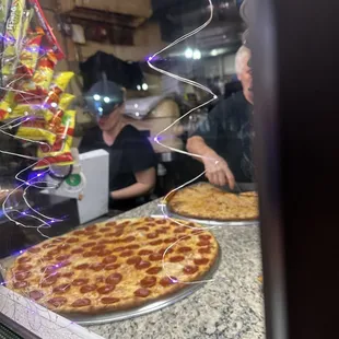 two pizzas in a window