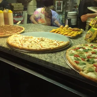 a variety of pizzas on display