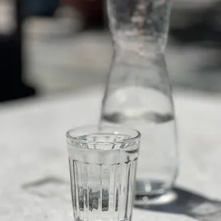 a glass and a pitcher on a table